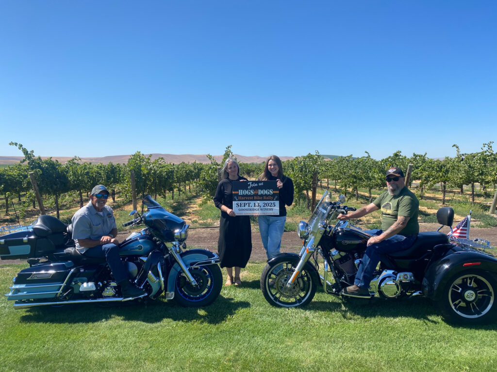 Motorcyclists at vineyard holding bike rally sign