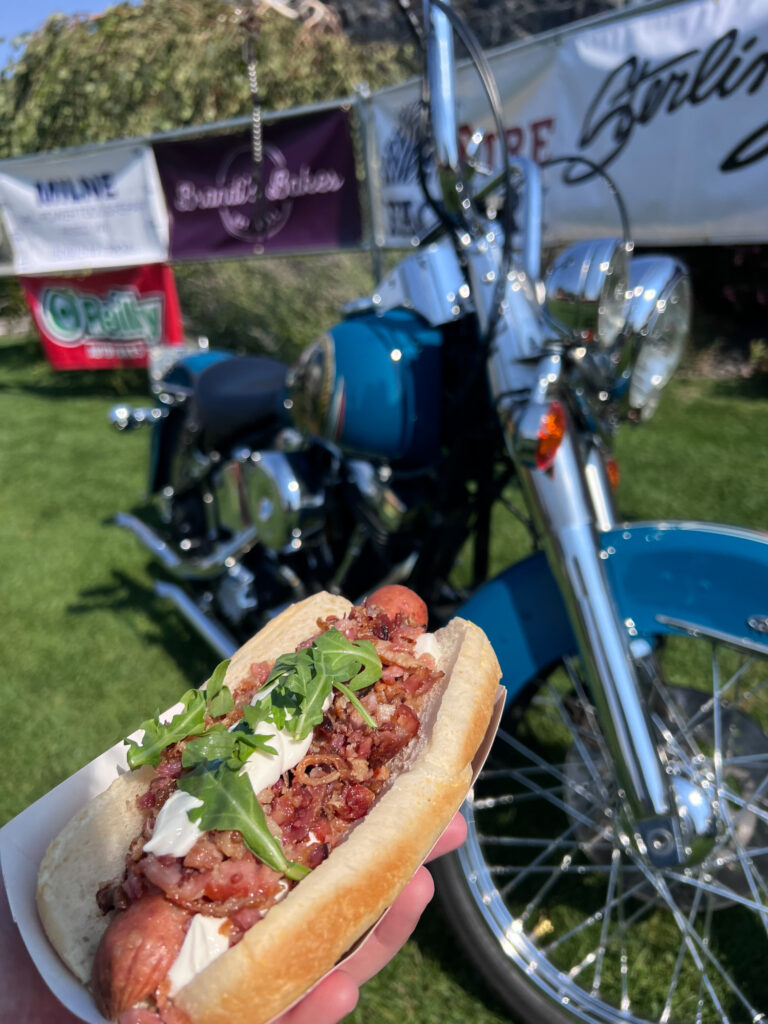 Gourmet hot dog in front of vintage motorcycle