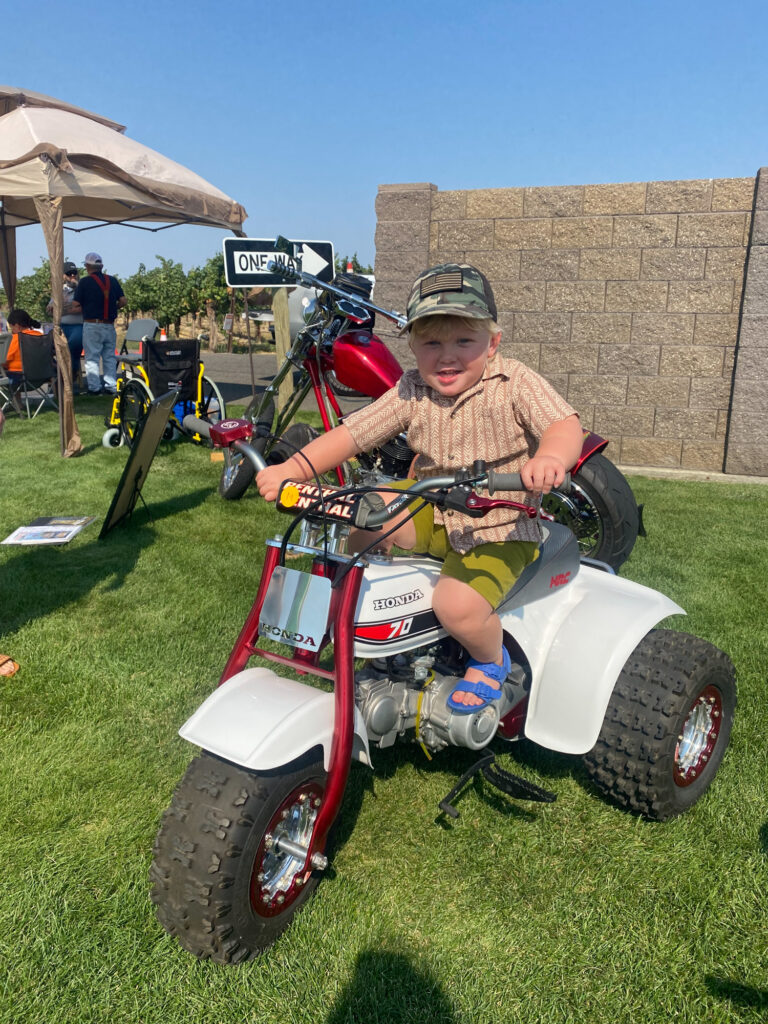 Toddler sitting on small Honda three-wheeler ATV
