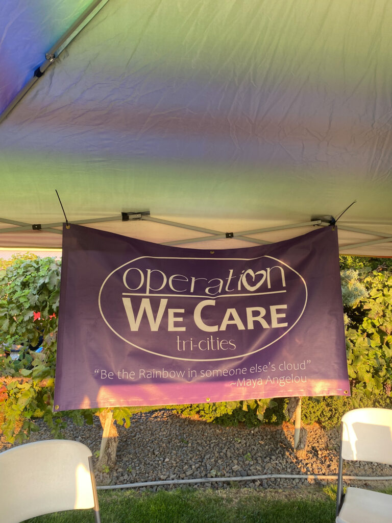 Operation We Care banner under outdoor canopy