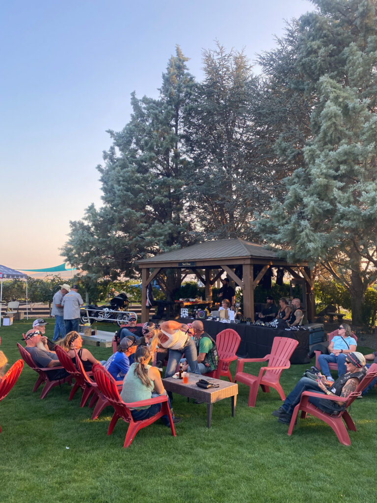 Outdoor gathering with gazebo and red chairs